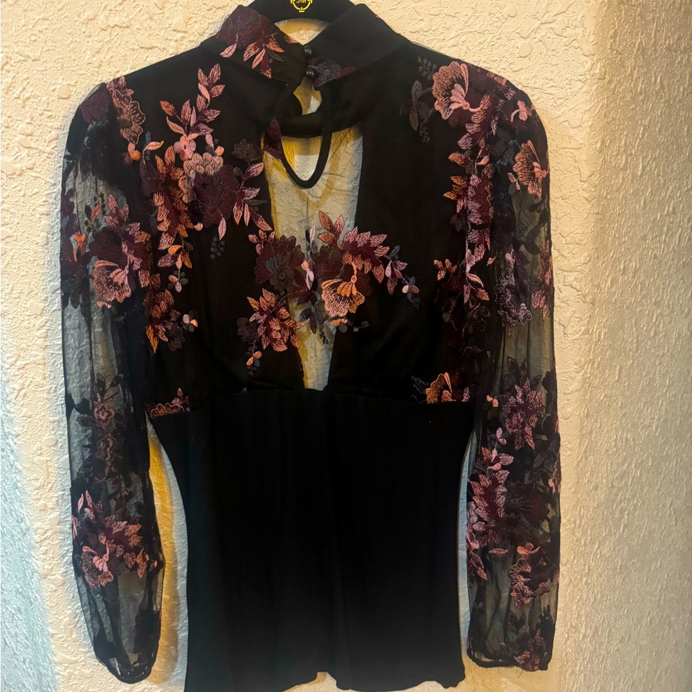 Surplice style low-cut top with embroidery neck and sleeves. NWOT.